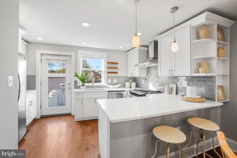 a kitchen with a table chairs stove and wooden floor