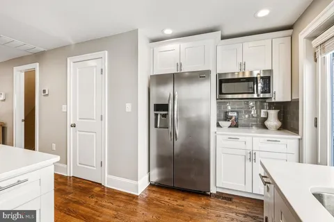 a kitchen with a refrigerator sink and cabinets