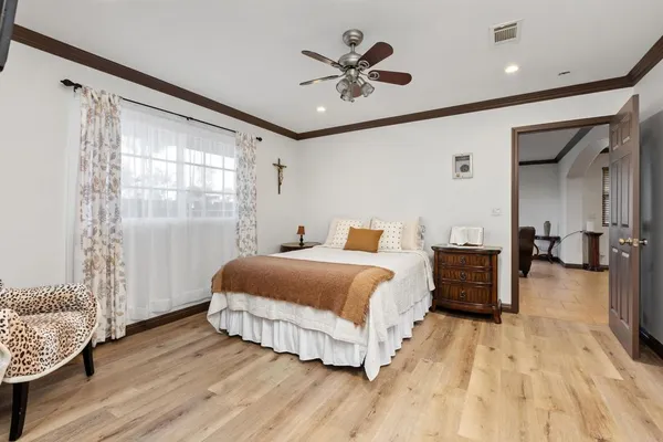 a spacious bedroom with a bed and a chandelier