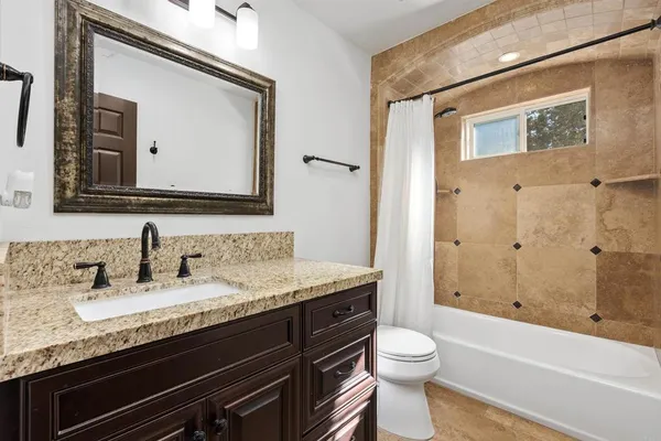 a bathroom with a granite countertop sink toilet and shower