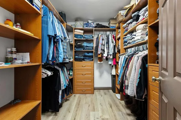 a view of walk in closet with clothes and shoes