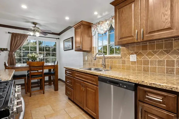 a kitchen with stainless steel appliances granite countertop a sink and a counter space