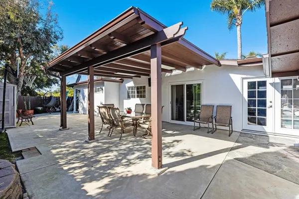 a view of a dinning table and chairs in patio of the house