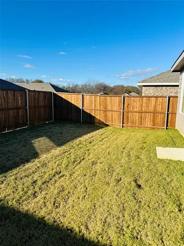 a view of a backyard with wooden fence