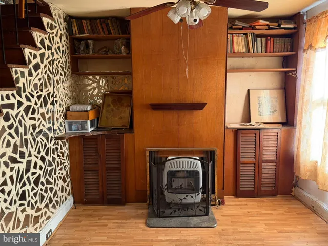 a view of a livingroom with furniture a ceiling fan and wooden floor