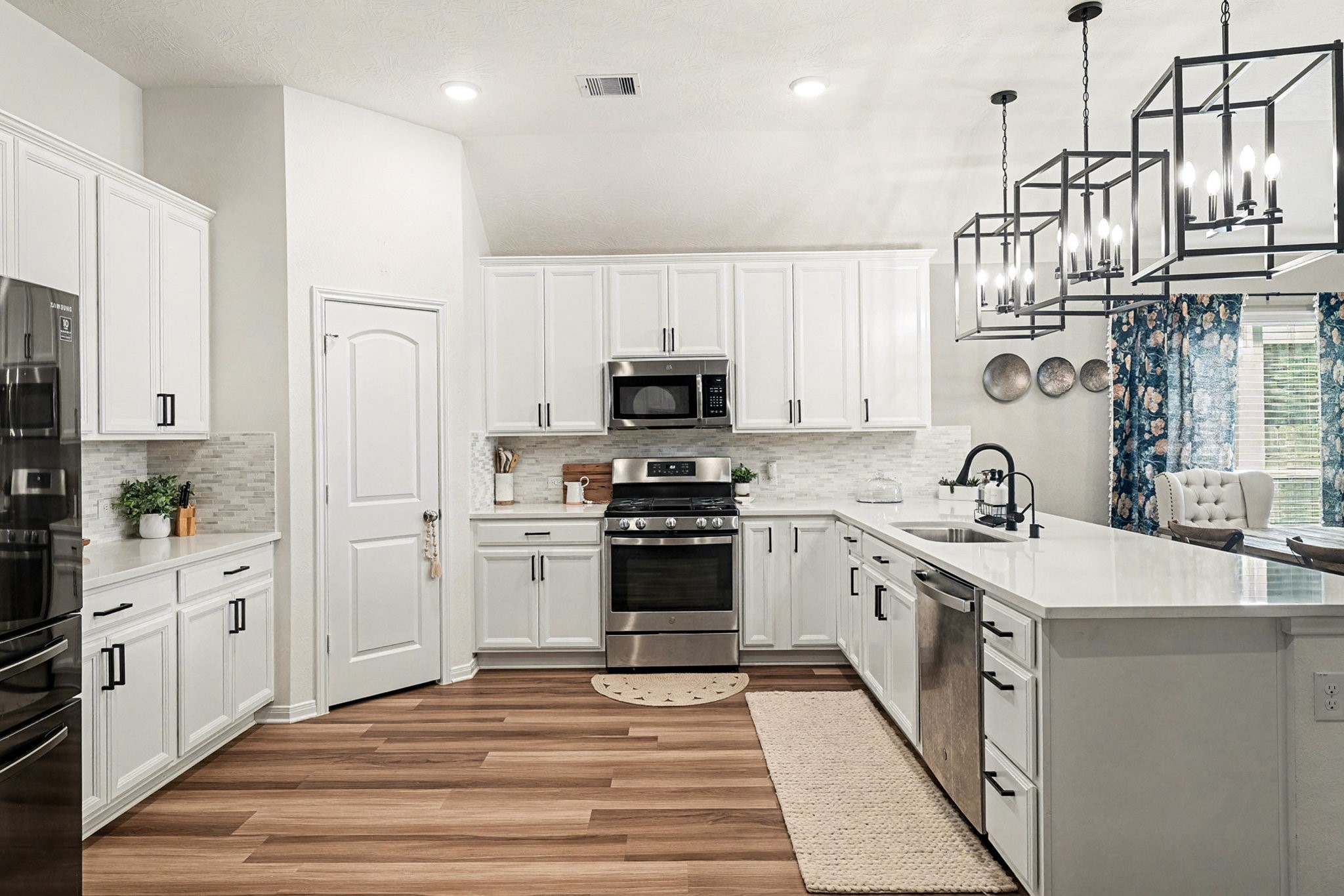 3309 Rolling View Court Conroe, TX 77301 - Photo 6 of 27 Chef's DREAM kitchen with ample countertop space, bright cabinetry, and stunning light fixtures.