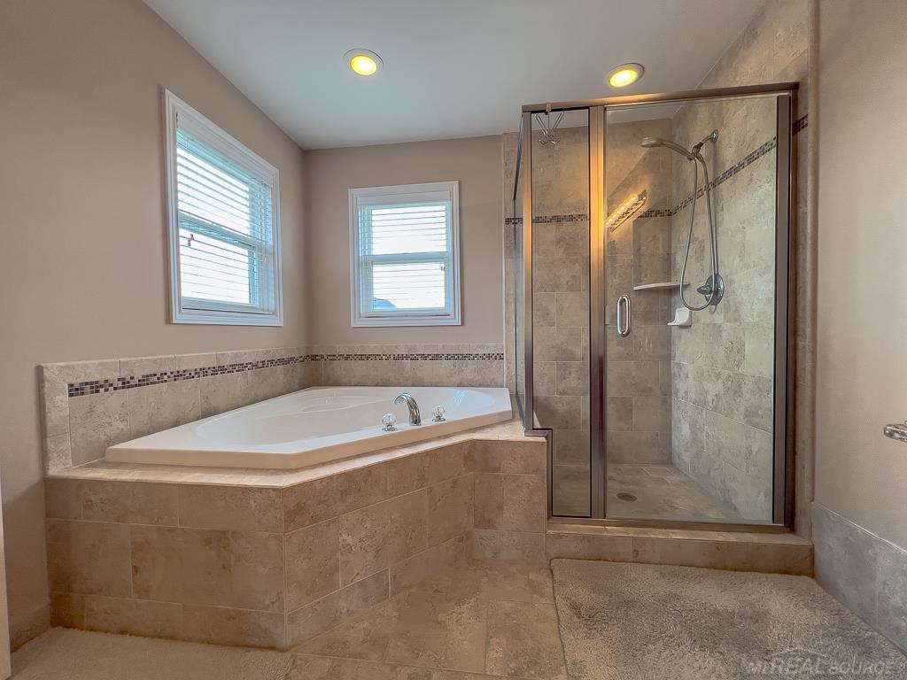 16070 Moore Park Road Macomb, MI 48044 - Photo 33 of 76 Primary Ensuite with nice layout. Natural light, recessed light, and vanity lighting perfectly placed. Euro shower enclosure & jetted tub.