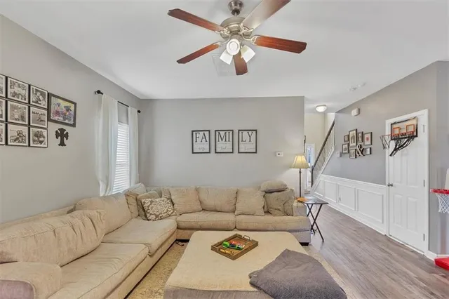 a living room with furniture and a ceiling fan