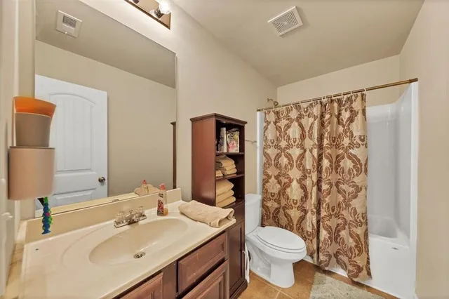 a bathroom with a sink a toilet and shower curtain