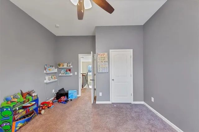 a view of room with toys and ceiling fan