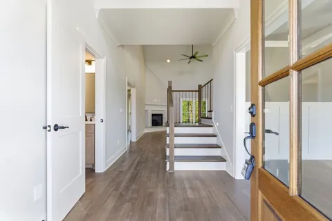a view of a hallway with wooden floor and staircase