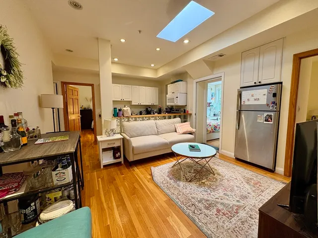 a living room with stainless steel appliances furniture a rug and a view