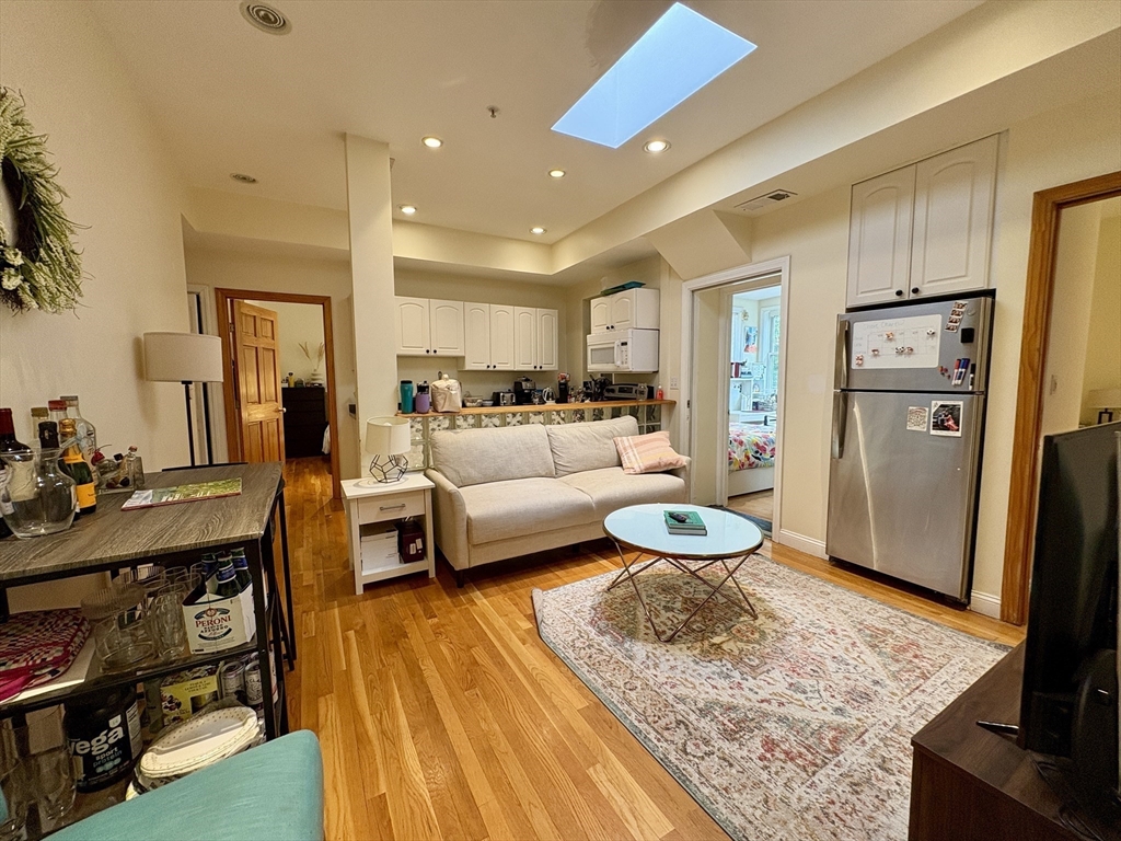 a living room with stainless steel appliances furniture a rug and a view