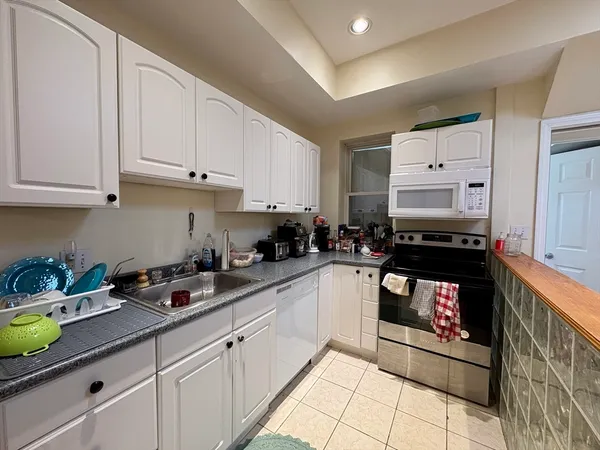 a kitchen with stainless steel appliances granite countertop a sink and a stove