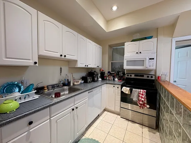 a kitchen with stainless steel appliances granite countertop a sink and a stove