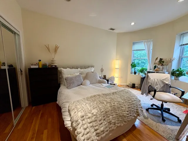 a bedroom with a bed and wooden floor