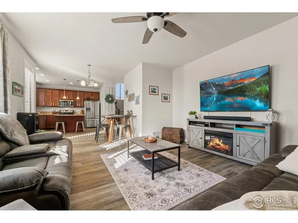 a living room with furniture and a flat screen tv with kitchen view