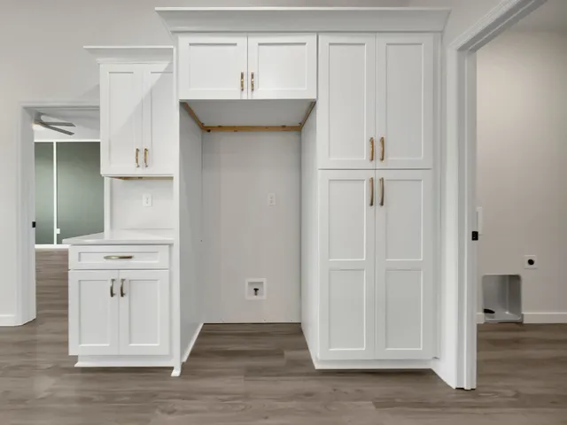 an empty room with wooden floor and cabinet