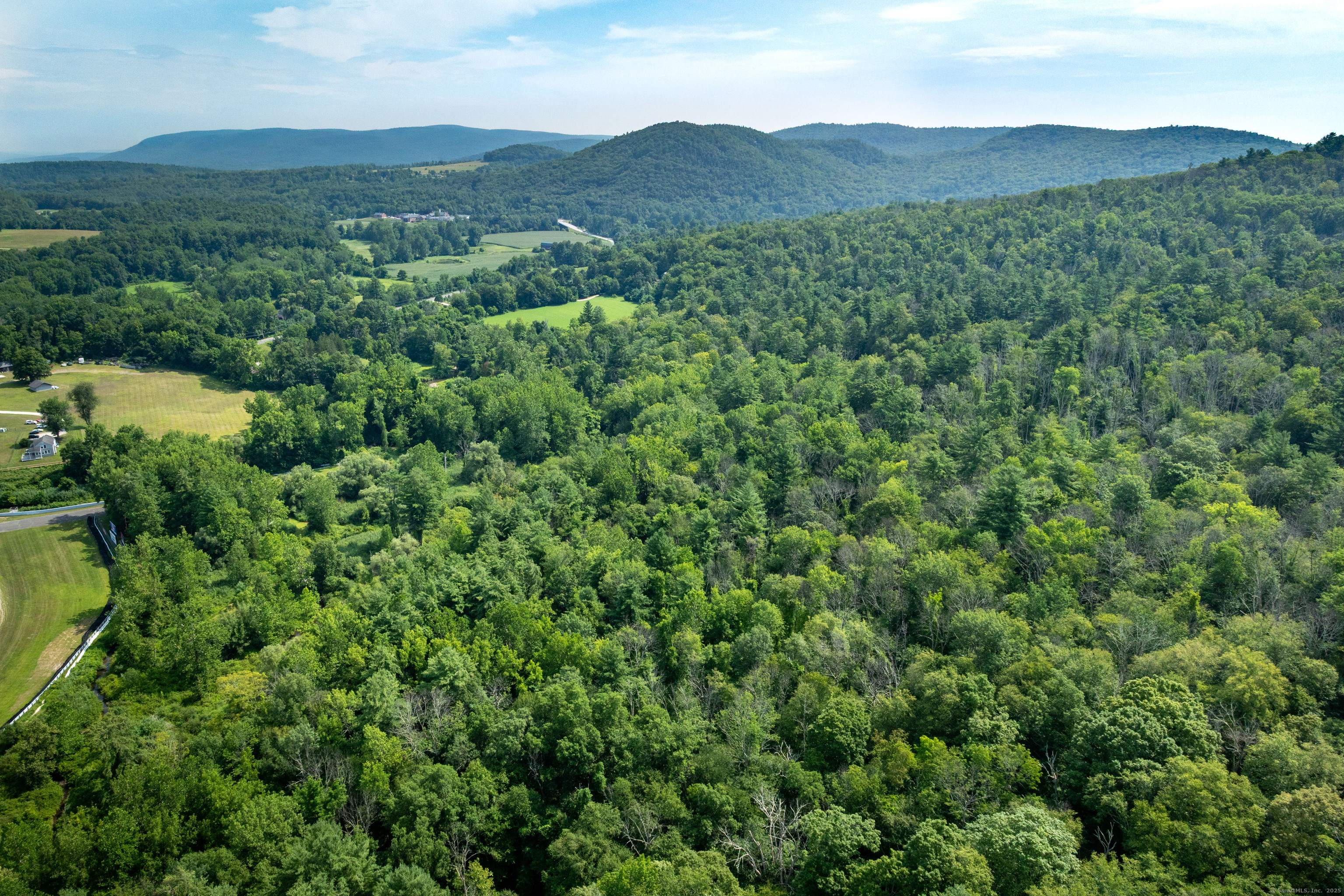 0 Lime Rock Road Lakeville, CT 06039 - Photo 13 of 27 a view of a lush green hillside and a houses