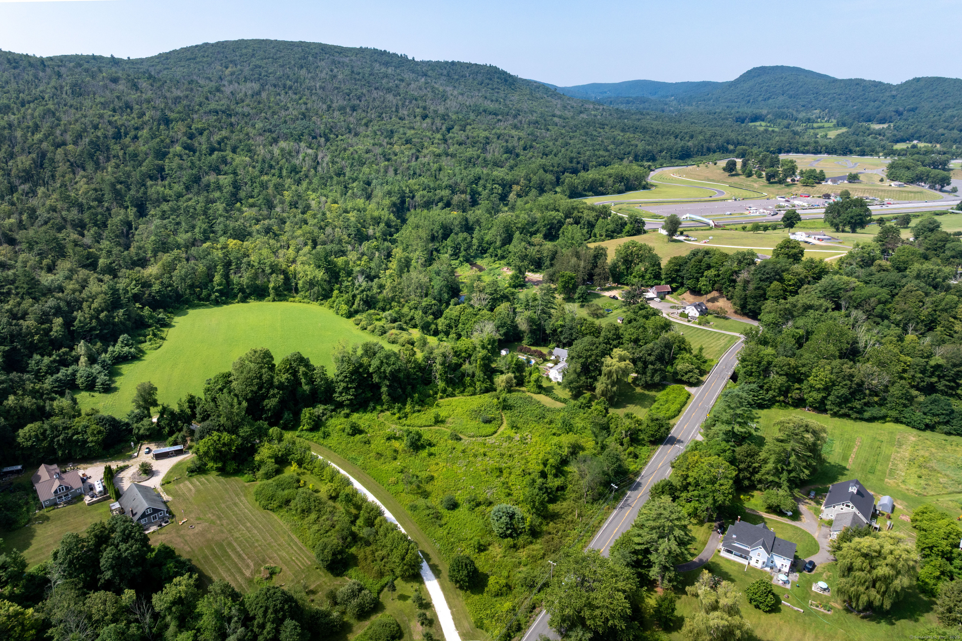 0 Lime Rock Road Lakeville, CT 06039 - Photo 16 of 27 an aerial view of green landscape with trees houses and mountain view