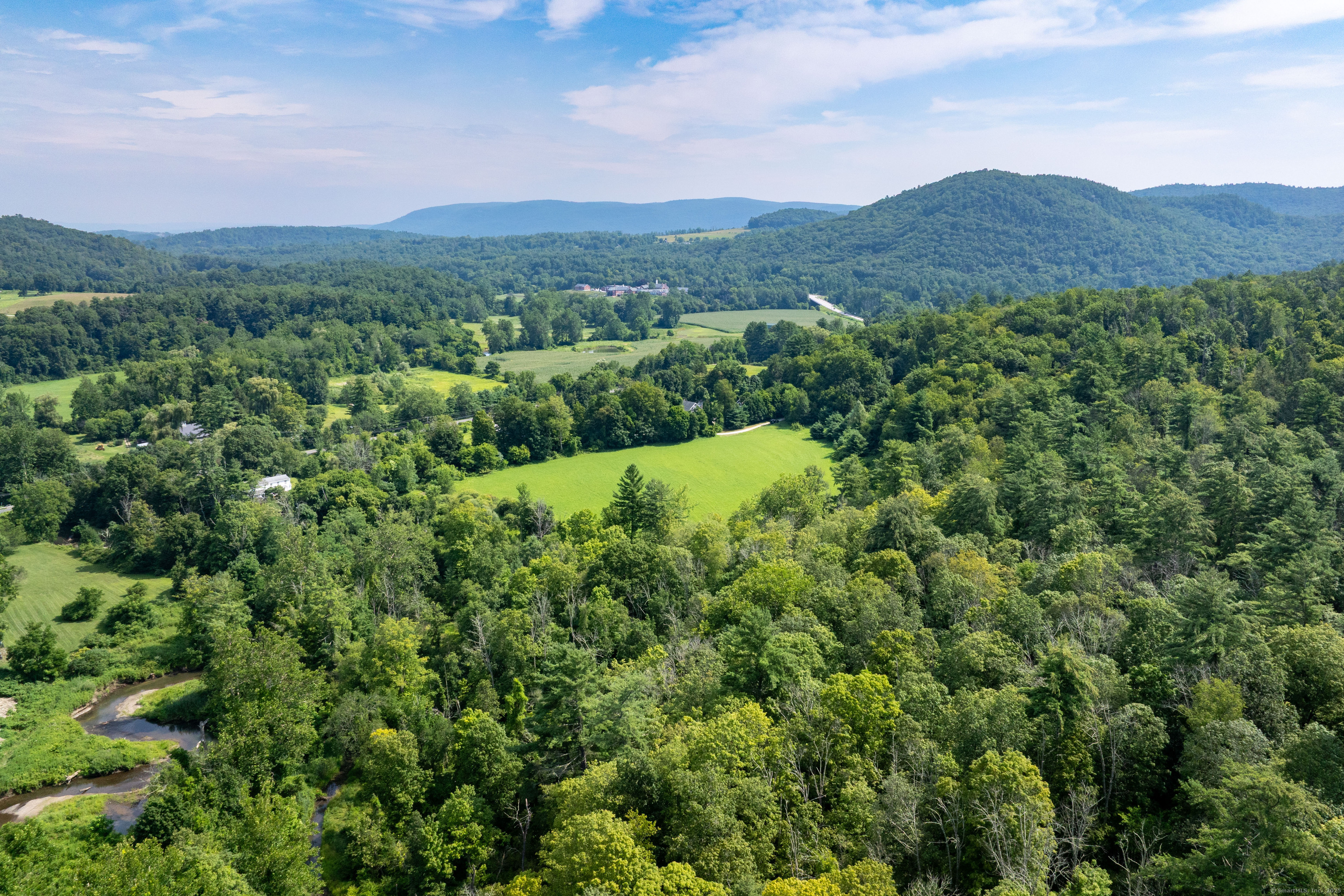 0 Lime Rock Road Lakeville, CT 06039 - Photo 18 of 27 a view of a lush green hillside and a houses