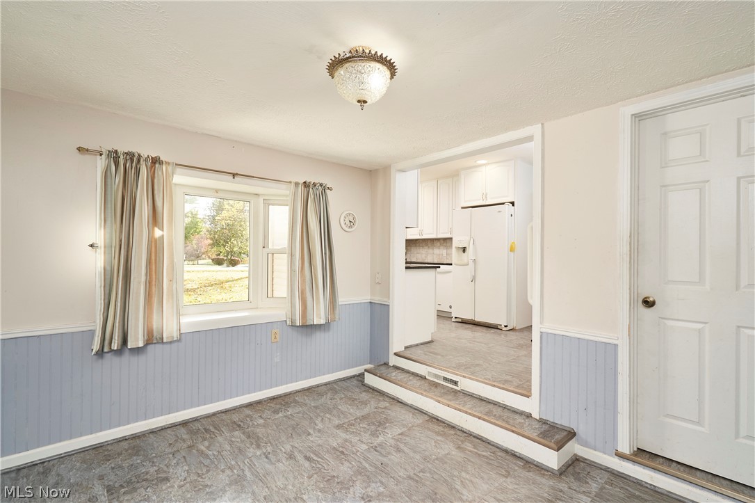 2941 Sweitzer Road Uniontown, OH 44685 - Photo 7 of 16 Unfurnished room with a wainscoted wall and a textured ceiling