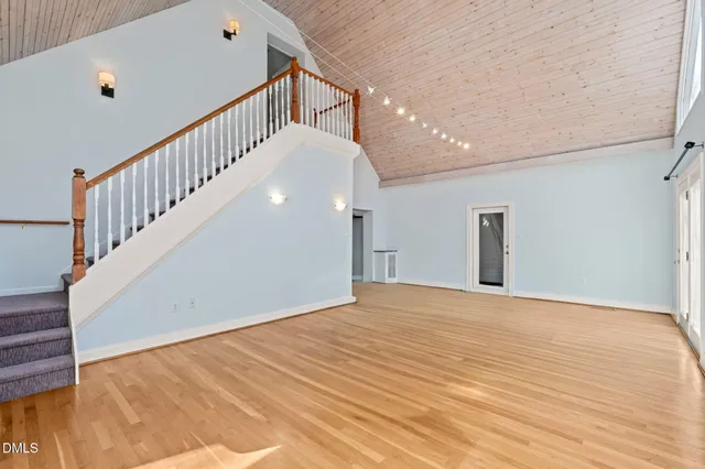 a kitchen with a stove a center island a sink cabinets and wooden floor