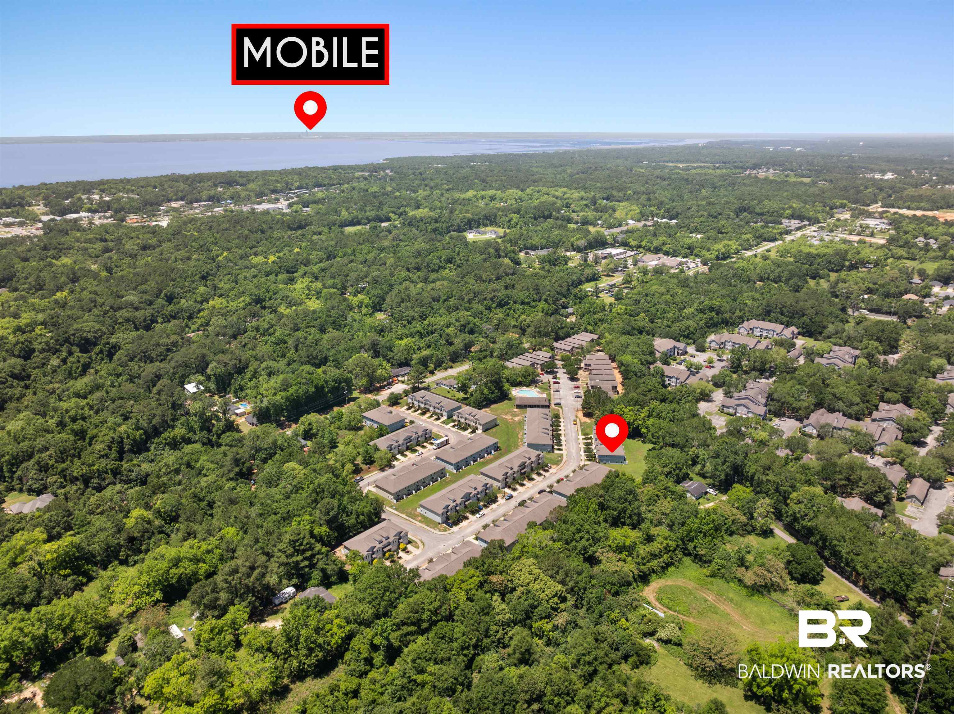 25806 Pollard Road, Unit 6 Daphne, AL 36526 - Photo 38 of 38 Aerial perspective showcasing a residential area surrounded by abundant mature trees and proximity to a large body of water