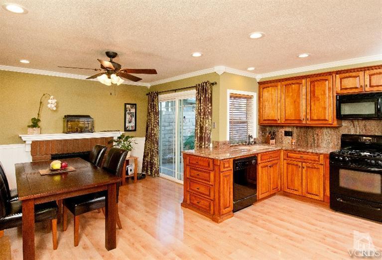 13452 East Quail Summit Road Moorpark, CA 93021 - Photo 2 of 15 a large kitchen with stainless steel appliances granite countertop a stove top oven a sink a dining table and chairs