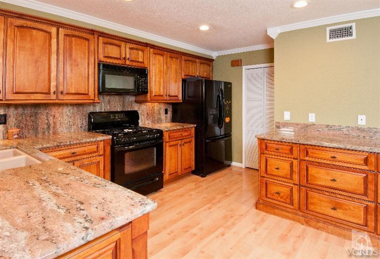 13452 East Quail Summit Road Moorpark, CA 93021 - Photo 4 of 15 a kitchen with stainless steel appliances granite countertop a refrigerator stove top oven and sink