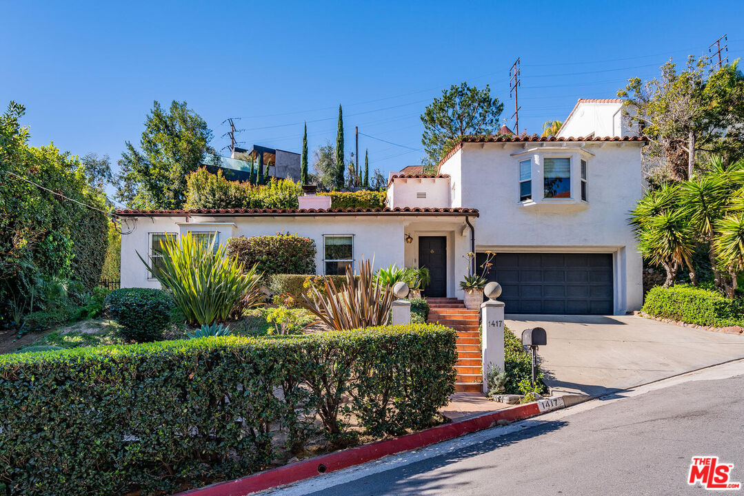1417 Queens Road Los Angeles, CA 90069 - Photo 1 of 25 a front view of a house with a garden and tree