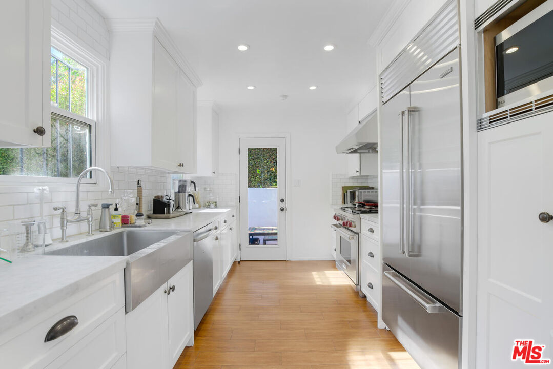 1417 Queens Road Los Angeles, CA 90069 - Photo 10 of 25 a large kitchen with stainless steel appliances lots of counter space and a sink
