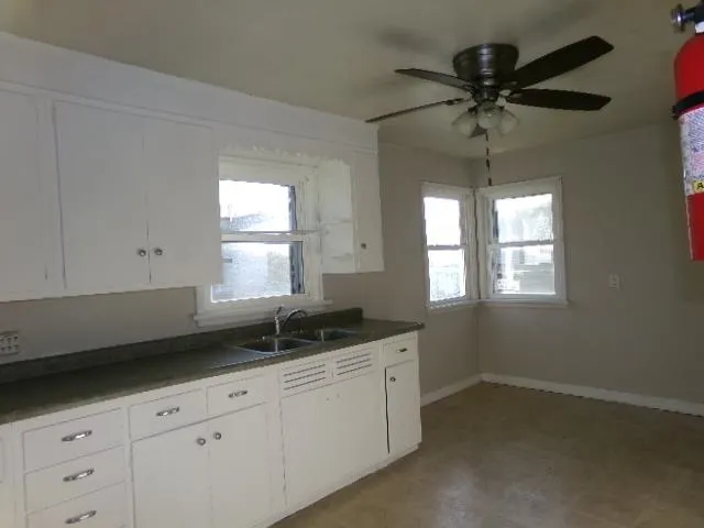 a kitchen with a sink window and cabinets