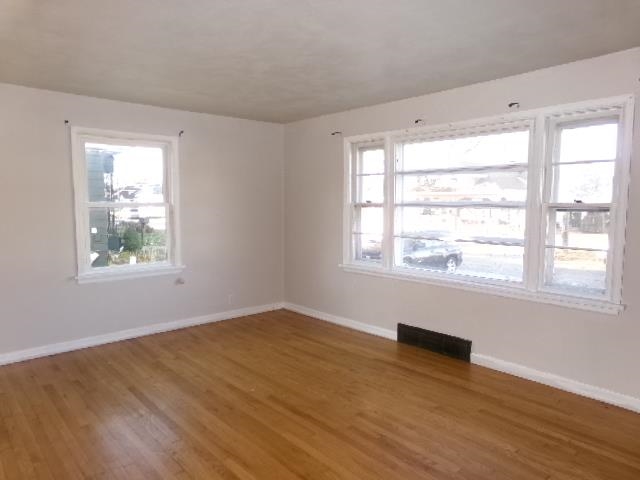 321 West Garfield Street Freeport, IL 61032 - Photo 4 of 11 a view of an empty room with wooden floor and a window