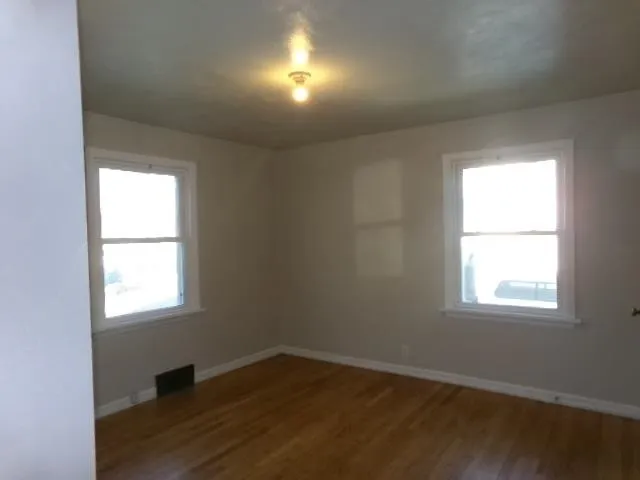 an empty room with wooden closet and windows
