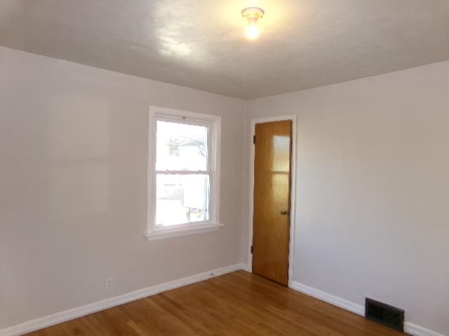 321 West Garfield Street Freeport, IL 61032 - Photo 7 of 11 an empty room with wooden floor and a window