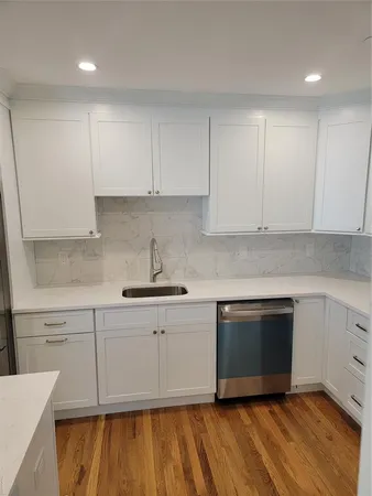 a kitchen with granite countertop white cabinets stainless steel appliances and sink