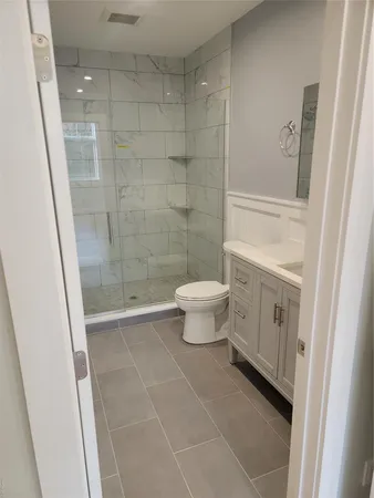a bathroom with a toilet a sink a shower and mirror