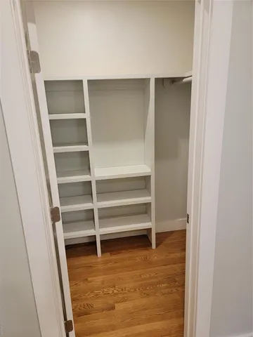 a view of walk in closet with empty racks