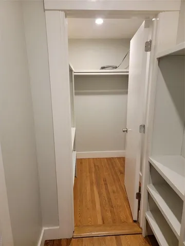 a view of walk in closet with wooden floor