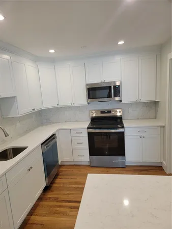 a kitchen with granite countertop a stove top oven and cabinets