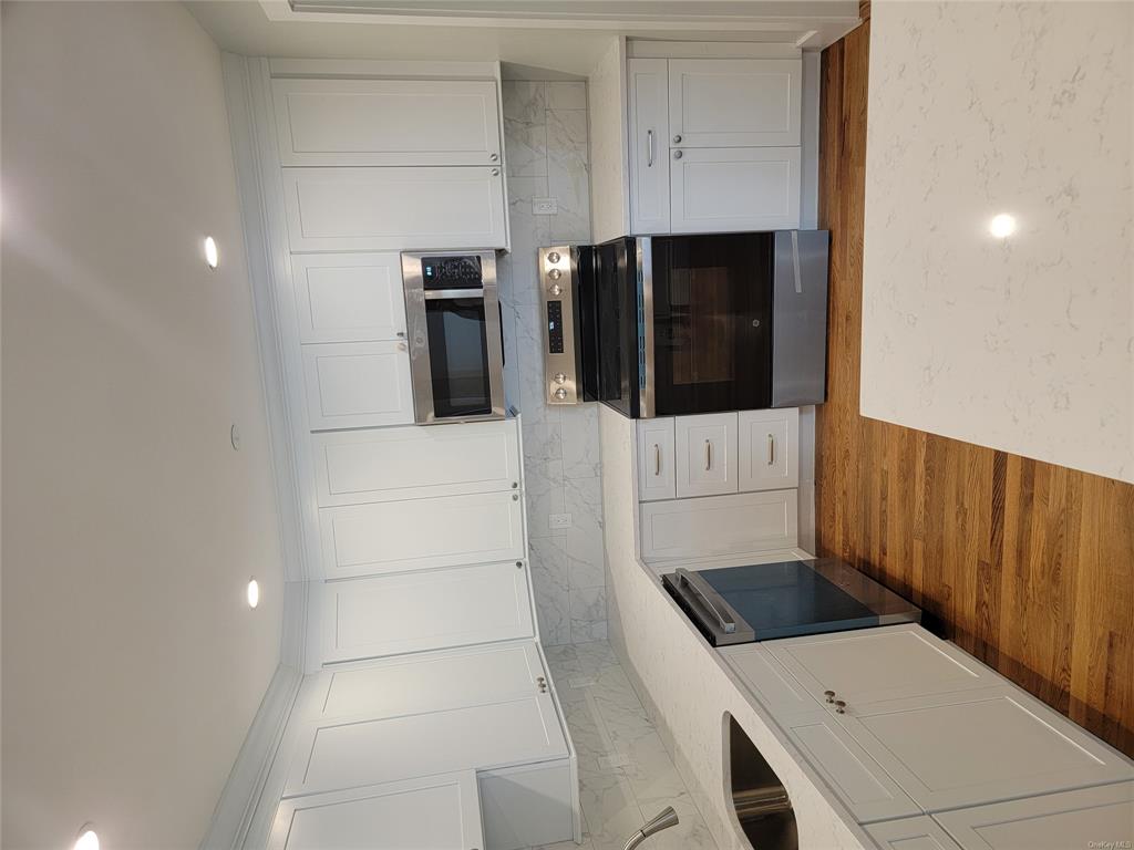 731 Broadway, Unit 2 Valhalla, NY 10595 - Photo 3 of 27 a kitchen with granite countertop a stove top oven and cabinets