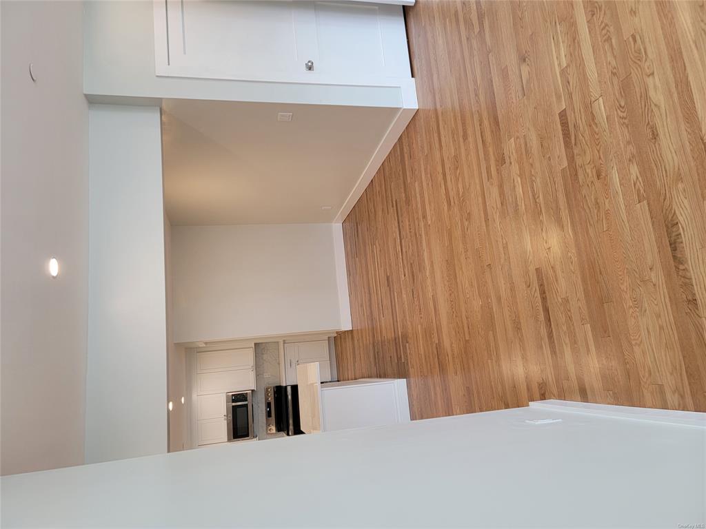 731 Broadway, Unit 2 Valhalla, NY 10595 - Photo 7 of 27 a view of kitchen and empty room with wooden floor