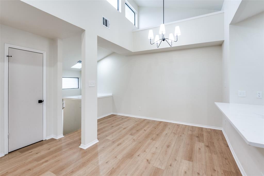 17490 Meandering Way, Unit 2202 Dallas, TX 75252 - Photo 19 of 24 Vaulted ceiling with transom windows and a modern chandelier