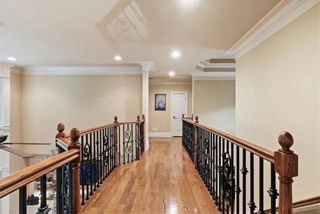 a spacious bedroom with a bed a dresser and a chandelier