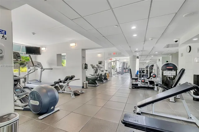 a room with gym equipment and lots of mirrors