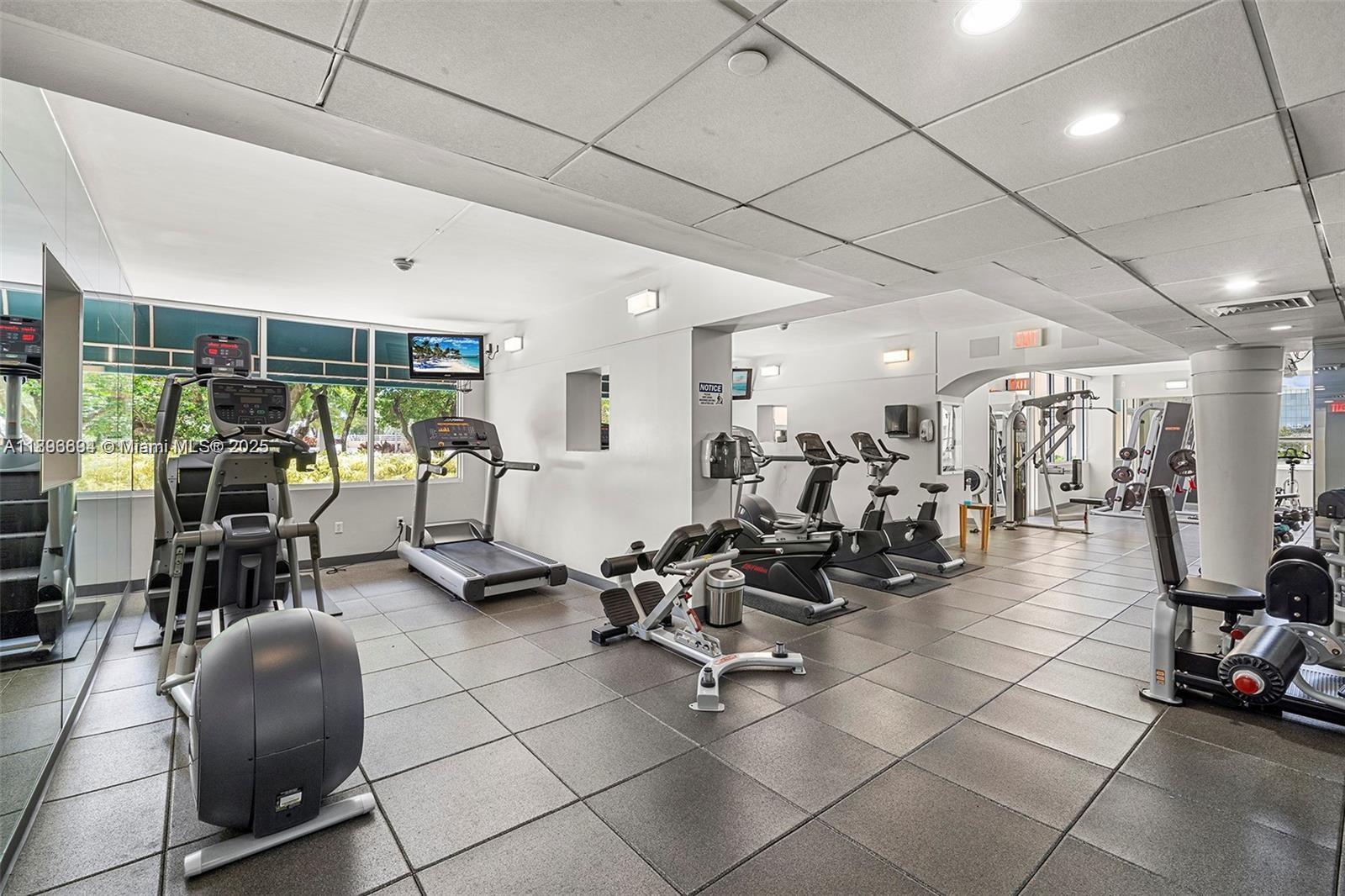 888 Brickell Key Drive, Unit 2607 Miami, FL 33131 - Photo 35 of 43 a room with gym equipment and lots of mirrors