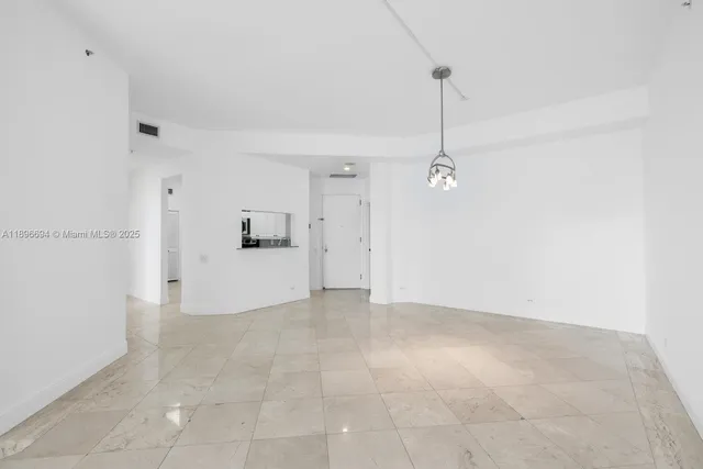 a view of a kitchen with a refrigerator and white cabinets