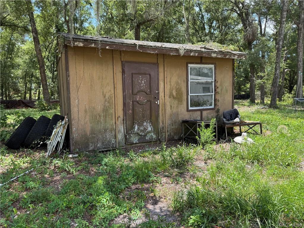 5590 Northwest 76th Avenue Chiefland, FL 32626 - Photo 15 of 22 a view of a backyard with potted plants and large tree