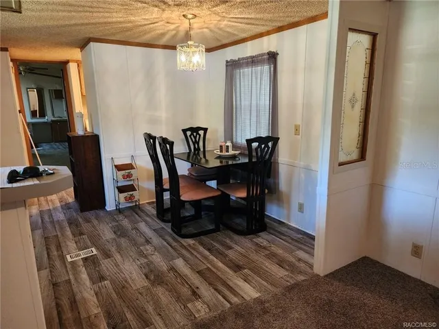 a view of a dining room with furniture and a chandelier